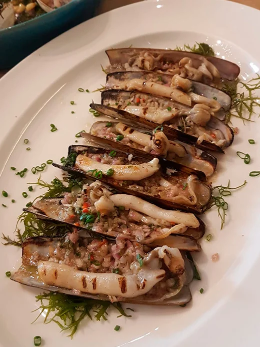 Razor clam dish served at a restaurant, sourced from Kostera's purified bivalve mollusks